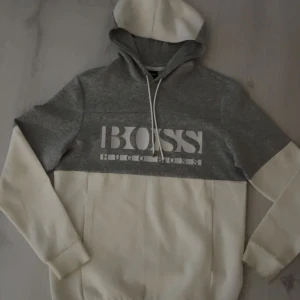 Grå och vit hoodie från Hugo Boss (slutsåld överallt i alla storlekar!) - Säljer en eftertraktad grå och vit hoodie från Hugo Boss. Slutsåld överallt online! Köpt för 1759kr. Säljer för mycket billigare. Använts max 2 gånger.