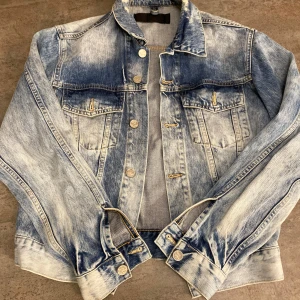 Blå jeansjacka från Never Denim - Säljer en snygg blå jeansjacka från Never Denim i storlek M. Jackan har en klassisk design med knappar framtill och två bröstfickor. Perfekt för vår och höst! 🧥