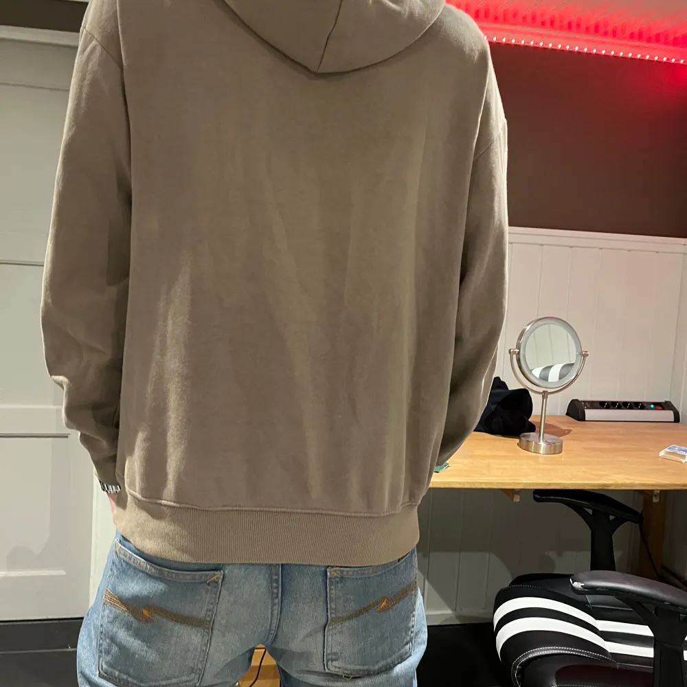 Säljer en snygg beige hoodie med tryck på bröstet och snygg passform. Nypris 299kr, mitt pris 159kr. Tröjor & Koftor.