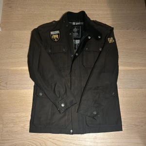 Svart jacka från Morris - Snygg svart jacka från Morris med broderade detaljer och rutigt foder. Skicket är som nytt, inga tecken på användning. OBS!! Storleken som anges är XS men passar perfekt för dig som i vanliga fall bör M. Perfekt för höst och vår, men även till vintern då den är rejäl och håller värmen ordentligt. Skriv vid frågor eller funderingar!😊