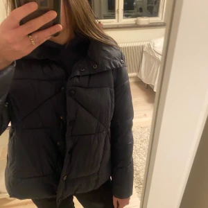 Mörkblå pufferjacka - Säljer en snygg mörkblå pufferjacka med knappar och hög krage som går att vika ner. Priset går att diskutera vid snabbaffär. Storlek L men passar mig som är en S! Originalpris runt 1200 kr. 