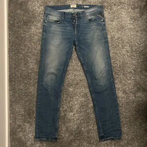 Replay Grover - Säljer ett par snygga blå jeans från Replay, modell Grover. De har en klassisk femficksdesign med knappgylf och en lätt tvättad look. Perfekta för en avslappnad stil. Vid eventuella funderingar så är det bara att höra av sig!