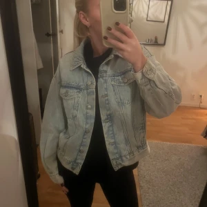 Ljusblå jeansjacka - Säljer en snygg ljusblå jeansjacka i normal passform. Jackan har långa ärmar och knappar framtill. Perfekt för vår och sommar, och funkar både till vardags och fest. Den är i bra skick och redo för en ny ägare! Storlek S