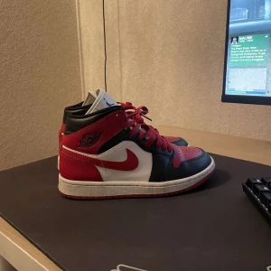 Nike Air Jordans i rött och svart - Säljer ett par snygga Nike Air Jordans i klassisk röd, svart och vit färgkombination. Skorna har en cool design med snörning och den ikoniska Air Jordan-loggan på plösen. Perfekta för både vardag och fest! 🏀