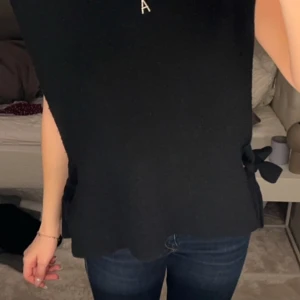 Svart ärmlös topp från NA-KD - Snygg svart ärmlös topp från NA-KD med knytning i sidorna. Tillverkad i ett mjukt material som ger en bekväm passform.