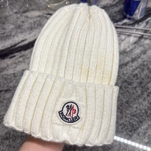 Vit ribbad Moncler mössa  - Snygg vit ribbad mössa från Moncler med broderad logga framtill. Oanvänd
