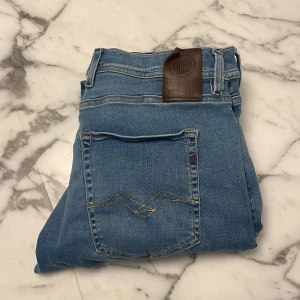 Blå jeans från Replay - Hej! Jag säljer dessa riktigt feta Replay jeans i model grover/ hyperflex i storlek w33 l32! Jeansen är i bra skick med en liten defekt, tagen på baksidan sitter lite löst. Hör av er om ni har frågor!😊