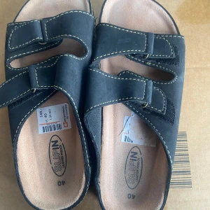 Svarta sandaler från Slipin - Svarta sandaler från Slipin med justerbara remmar och kontrasterande sömmar. Perfekta för en avslappnad stil.