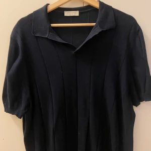 Mörkblå kortärmad pikétröja från Gran Sasso!   - Snygg mörkblå pikétröja från Gran Sasso i fräsch bomull. Tröjan har korta ärmar och en klassisk krage, perfekt för en stilren look. Tillverkad i Italien. Helt ok skick! 