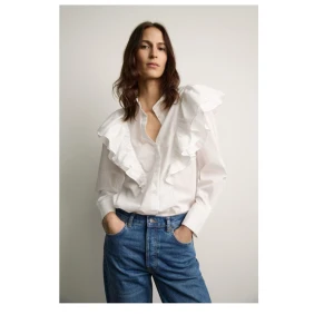 Vit blus med volangdetaljer - En favorit blus, oanvänd med lapp kvar då jag köpte 2st. Den är slutsåld 💕✨.  Kom med prisförslag!