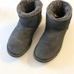 Grå boots från UGG - UGG W classic mini  Färg:Grå Storlek 37 som är Små i storleken , passar dig bäst med storlek 36-36,5 Mindre slitage,repor kan finnas. Vänligen observera att jag inte har öppetköp. Ordpris:1999kr skickas endast med PostNord.