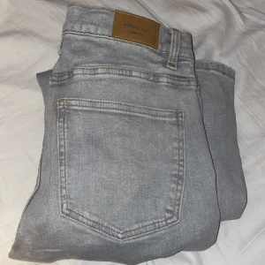 Low bootcut jeans Gina Tricot  - Säljer dessa ljusgrå low Waist bootcut jeans från Gina och dom är i storlek 40, köpte tyvärr fel storlek! Ny pris är 499kr. Det ända jag gjort är att jag tagit av prislappen på plagget.