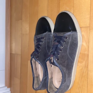 Grå sneakers med svart tå från Lanvin - Säljer dessa feta lanvins i storlek 44 nypris är 5000 mitt pris är 1750 men kan diskuteras. Färgen är grå skick 7/10 ingen box det är lite skador på undersulan som man ser på bilden, men är inget man märker av, kom privat om bilder eller pris! 