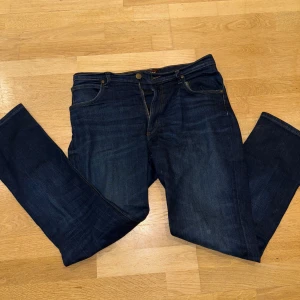 Mörkblå jeans från Lee - Snygga mörkblå jeans från Lee i modellen Brooklyn Straight. De har en klassisk femficksdesign och en bekväm passform. Perfekta för en avslappnad stil.