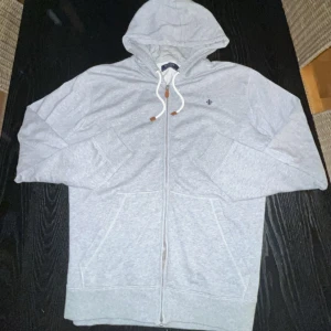 Morris Zip hoodie - Säljer en grå Morris zip hoodie. Den är i ett hyfsat bra skick, inga deffekter. Nypris:1295kr och mitt pris:450kr. Tveka inte att skriva för fler frågor och bilder. 