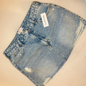 Blå jeanskjol mini - Snygg blå jeanskjol från PacSun med slitna detaljer, säljer den pågrund av att jag köpt fel storlek, sitter jätte fint på, helt ny testat en gång.💕✨ storlek 28 - S men passar även M