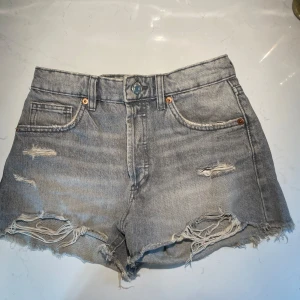 Grå jeansshorts från Zara - Säljer dessa snygga grå jeansshorts från Zara med slitna detaljer och fransig kant. Dessa är använda typ 2 gånger pga en passform som inte satt så bra , de är i storlek 34 som motsvarar XS❣️