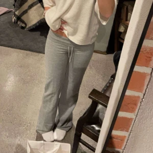 Grå mjukisbyxor med snörning - Säljer ett par bekväma grå mjukisbyxor med snörning i midjan. Perfekta för en avslappnad dag hemma eller på språng. Byxorna har en loose passform och är tillverkade i mjukt material för extra komfort.