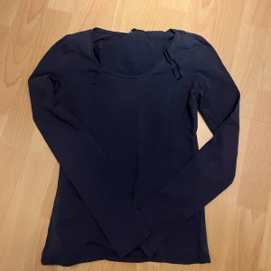 Marinblå långärmad topp - Säljer en stilren  långärmad topp. Perfekt för lager-på-lager eller att bära som den är. Toppen har en enkel design med rund halsringning.