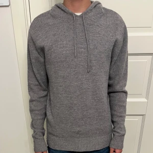 Grå stickad hoodie  - Säljer en stilren grå hoodie i stickad ullblandning från Kevin Trapps kollektion med About You. Storlek S. En mindre fläck på framsidan. Nypris ca 900kr. Hör gärna av dig!