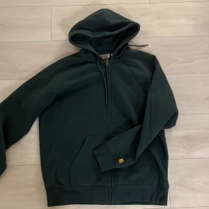 Mörkgrön zip- hoodie från Carhartt - Säljer en mörkgrön zip hoodie från Carhartt, endast använd 2 gånger så den är i väldigt bra skick! 