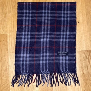 Burberry halsduk - Tjena! Säljer nu denna snygga mörkblåa Burberry halsduk i 100% cashmere. Halsduken är 150 cm, samt i bra skick men har en liten defekt som du kan se på sista bilden. Hör gärna av dig om du har några frågor eller vill se fler bilder!