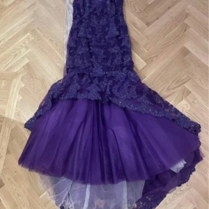 Lila glittrig långklänning / festklänning  - Säljer en fantastisk lila långklänning med glittriga detaljer och spets. Klänningen har en elegant passform och en dramatisk volangdetalj som ger en extra touch av glamour. Perfekt för speciella tillfällen! Säljer nu min vackra festklänning som jag haft EN gång på min systers bröllop. Storlek 12 (USA storlek) 44 europeisk storlek men skulle säga snarare än 38/40. I väldigt bra skick och köptes för 7500 kr.