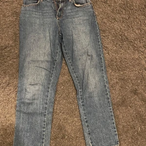 Blå jeans från Guess - Snygga blå jeans från Guess med klassisk femficksdesign och märkets logotyp på bakfickan. Perfekta för en avslappnad stil. De har en knappgylf och är tillverkade i slitstarkt denim.