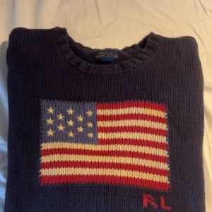 Mörkblå Polo Ralph Lauren - Stickad tröja från Ralp lauren med USA flaggan. Storlek 14-16 vilket är L i barn. Pris går att diskuteras vid snabb affär! Kom med privat med funderingar 😀