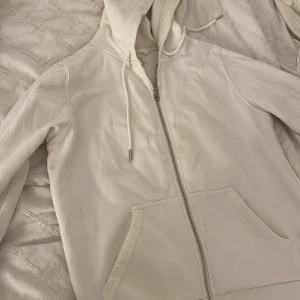 Vit hoodie från H&M -  En vit hoodie med dragkedja från H&M en liten fläck men syns knappt 