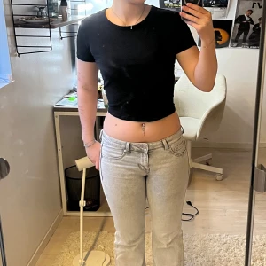 Svart croppad t-shirt - Säljer en svart croppad t-shirt med korta ärmar. Perfekt för en avslappnad stil. Enkel och stilren design som passar till det mesta. Köpt secondhand och tyvärr är lappen bortklippt, så har ingen aning vilket märke. 