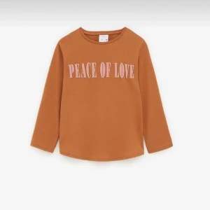 Brun långärmad tröja från Zara - Säljer en snygg brun långärmad tröja från Zara med texten 'Peace of Love' i rosa på framsidan. Perfekt för en avslappnad stil och passar bra till både jeans och kjol. Tröjan är i storlek 164 och är i bra skick.