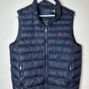 Ralph Lauren väst (ny) - Fick denna mörkblå Ralph Lauren väst i present men blir inte att den används. Den har använts Max 3 gånger så är exakt som ny som man ser på bilderna.  Köptes för 3200 på Zalando. Vid snabb och smidig affär är den din för 2000kr.