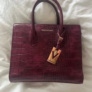 Valentino väska - Säljer min röda valentino väska❤️ Det finns lite skador på handtaget som syns på sista bilden. Mått: 30x25❤️ Köpt på plick