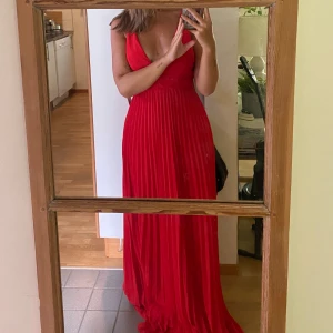 Röd Balklänning  - Underbar balklänning som tyvärr aldrig blivit använd. Lappar kvar. Öppenrygg och underbar längd som är perfekt för klackar. Jag är 168 och den är lång på mig! Fler bilder och videos finns.