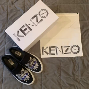 Kenzo skor - Kenzo skor (slip ons) i superbra skick. Nypris 1800, mitt pris 500kr. Storlek 43  Skick 9/10 Allt på bilden medföljer!