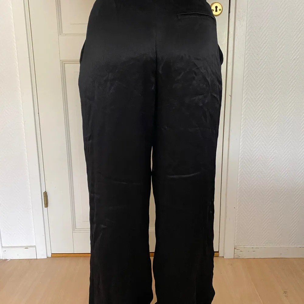 Svarta glansiga kostymbyxor Zara. Svårt att beskriva materialet men glansiga typ siden men tjocka så det är inte alls genomskinligt. Långa/stora på mig som är 160.. Jeans & Byxor.