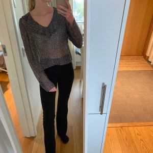 Blus från NAKD - Mönstrad blus från NAKD med volang upptill. Materialet är see through. Storlek 36.