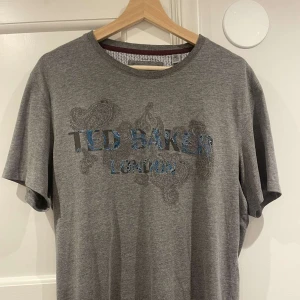 Snygg tisha  - Säljer denna snygga tisha med ett snyggt tryck. Som passar bra med trenden laidback. Bra skick och är ifrån märket Ted barker .  Tveka inte med att höra av er!