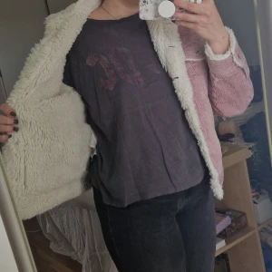 Rosa teddyjacka från SOYA - Mysig rosa teddyjacka från SOYA i storlek XS. Aningen större i stormeken. Den har knappar framtill och två fickor med lock på bröstet. Manchestermaterial utanpå och fluffig vit fuskpäls på insidan. Knappt använd.