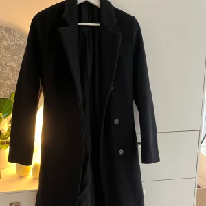 Filippa K kappa - Kappa från Filippa K Svart Storlek 34. Ena innerfickan är lite trasig. Går att sy ihop.