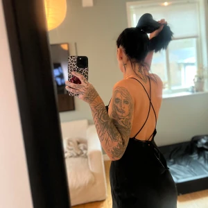 Svart axelbandslös klänning -  svart klänning med öppen rygg och smala axelband. Använd en gång 