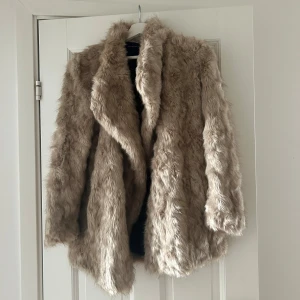 Pälsjacka - Beige pälsjacka (fuskpäls) från Zara i storlek S. Den är i bra skick men knappen har lossnat, finns en ny att sy på. 