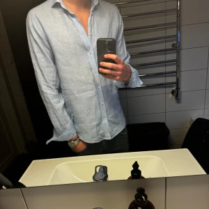 Ljusblå Linneskjorta Brunn & Stengade - Säljer denna riktigt snygga linneskjortan från Bruun & Stengade. Väldigt sparsamt använd och i nyskick. Köpt för 899kr på deras butik 