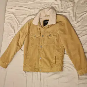 Säljer en snygg beige manchesterjacka från Hollister i storlek S. Jackan har en mysig fuskpälsfoder inuti och knappar framtill. Saknas knapp e en av armen men lätt att fixa. Perfekt för höst och vår! 🧥