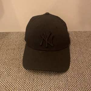 Yankees keps - Justerbar keps som nästan går med vad som helst i din garderob. Smidig och enkla färger har den och just därför passar den bra till dig som är ute efter keps