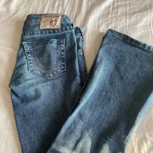 Blå jeans från True Religion - Säljer ett par snygga blå jeans från True Religion i bra skick. Dom är lågmidjade och bootcut. Lite långa på mig som är nästan 160cm. Köpta här på Plick. Pris går att diskutera