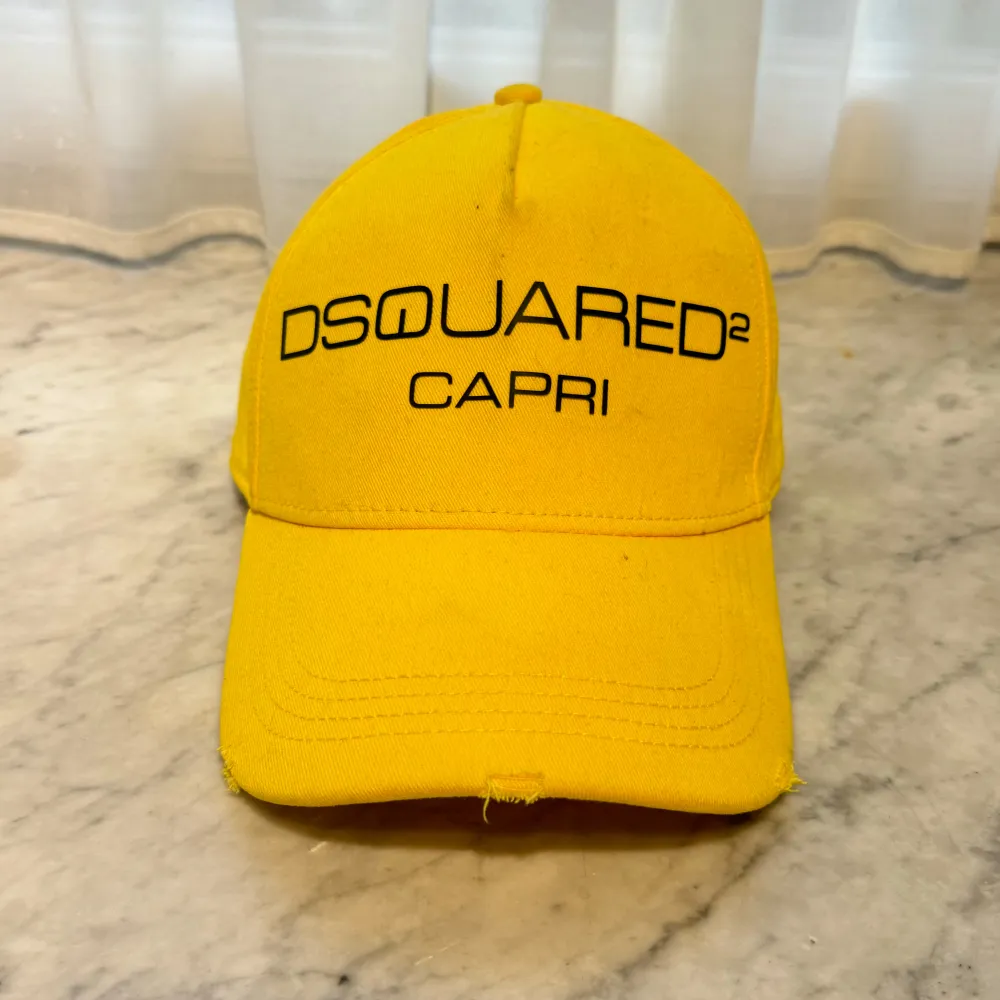 Säljer en snygg gul keps från Dsquared2 med texten 'CAPRI' broderad framtill. Kepsen har justerbar rem baktill för perfekt passform. Original.   🧢 Jag har flera kepsar till salu på min profil och lägger upp nya modeller regelbundet. . Accessoarer.