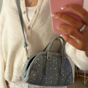 Glittrig Zara väska - Snygg väska i jeansmaterial med glittrande strassdetaljer. Bra skick men själva ”flärpen” på dragkedjan saknas (bild 4), men den går att använda ändå!💕