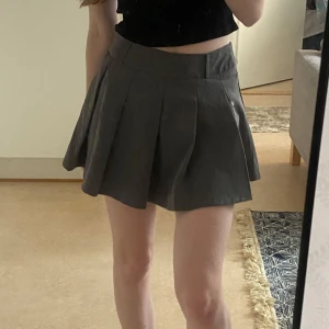 Grå kjol - Kjolen har inbyggda short. Aldrig använt. Står storlek XXS men är större i storleken, Skulle säga att den passar mer S-XS